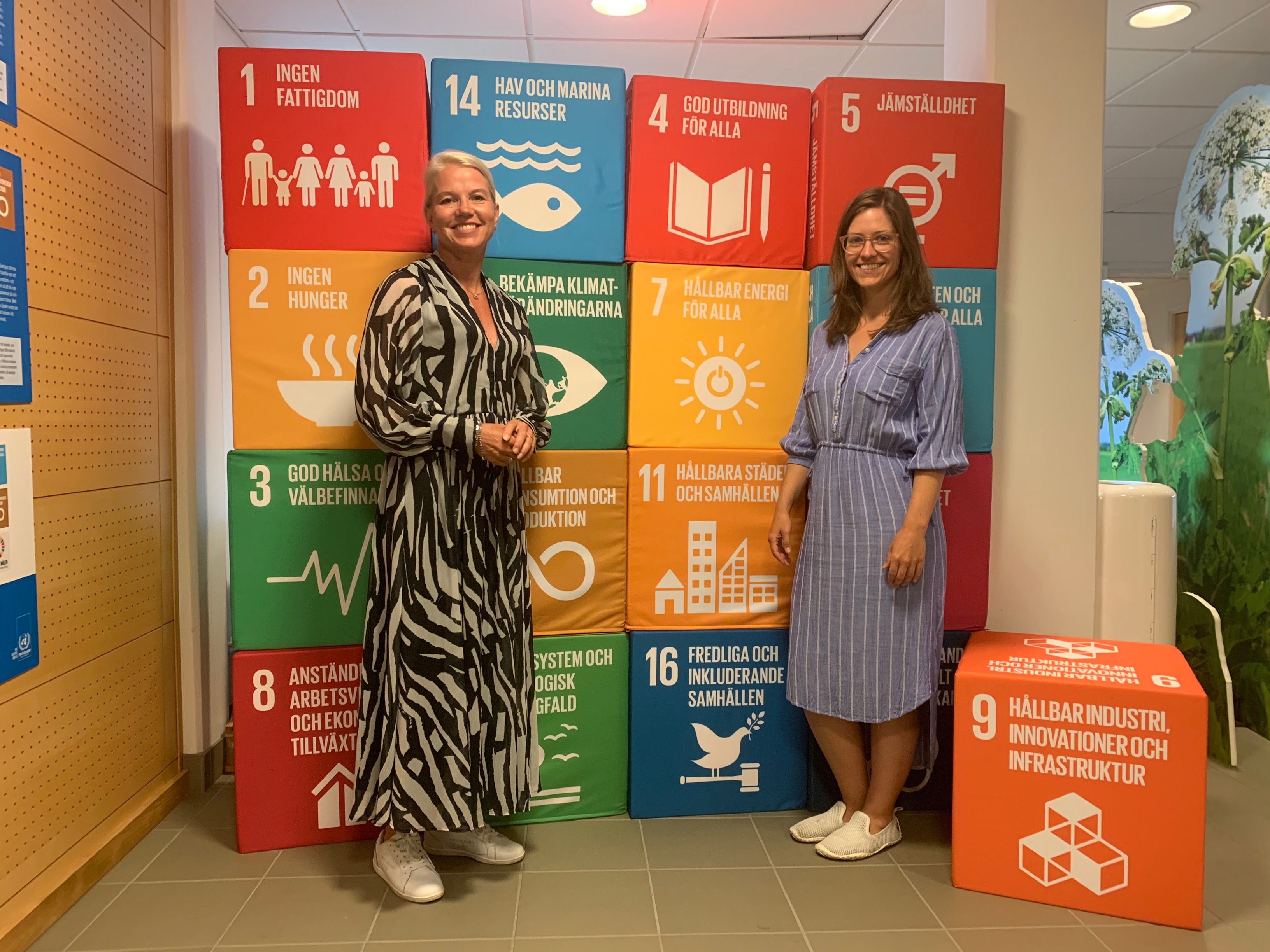 Carina Wutzler och Melissa Maxter framför färgglada klossar med de globala målen från Agenda 2030. 