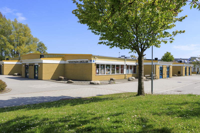 En byggnad med ett träd framför sig.