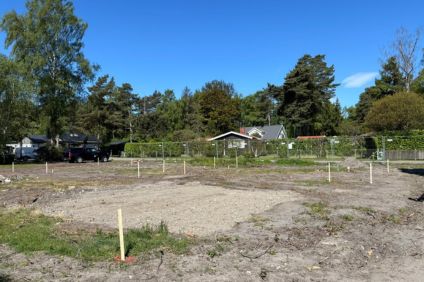 Stolpar är nedsatta i marken på en fastighet. De markerar grovutstakning.