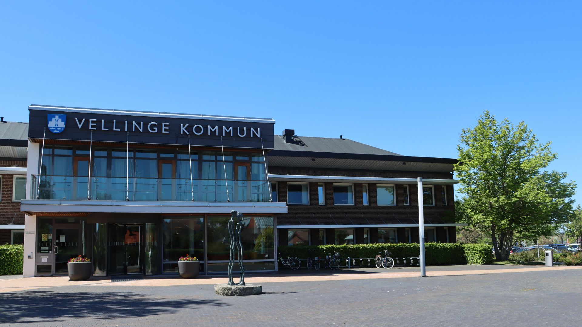 En brun tegelbyggnad med bokstäverna Vellinge kommun ovanför entrén.