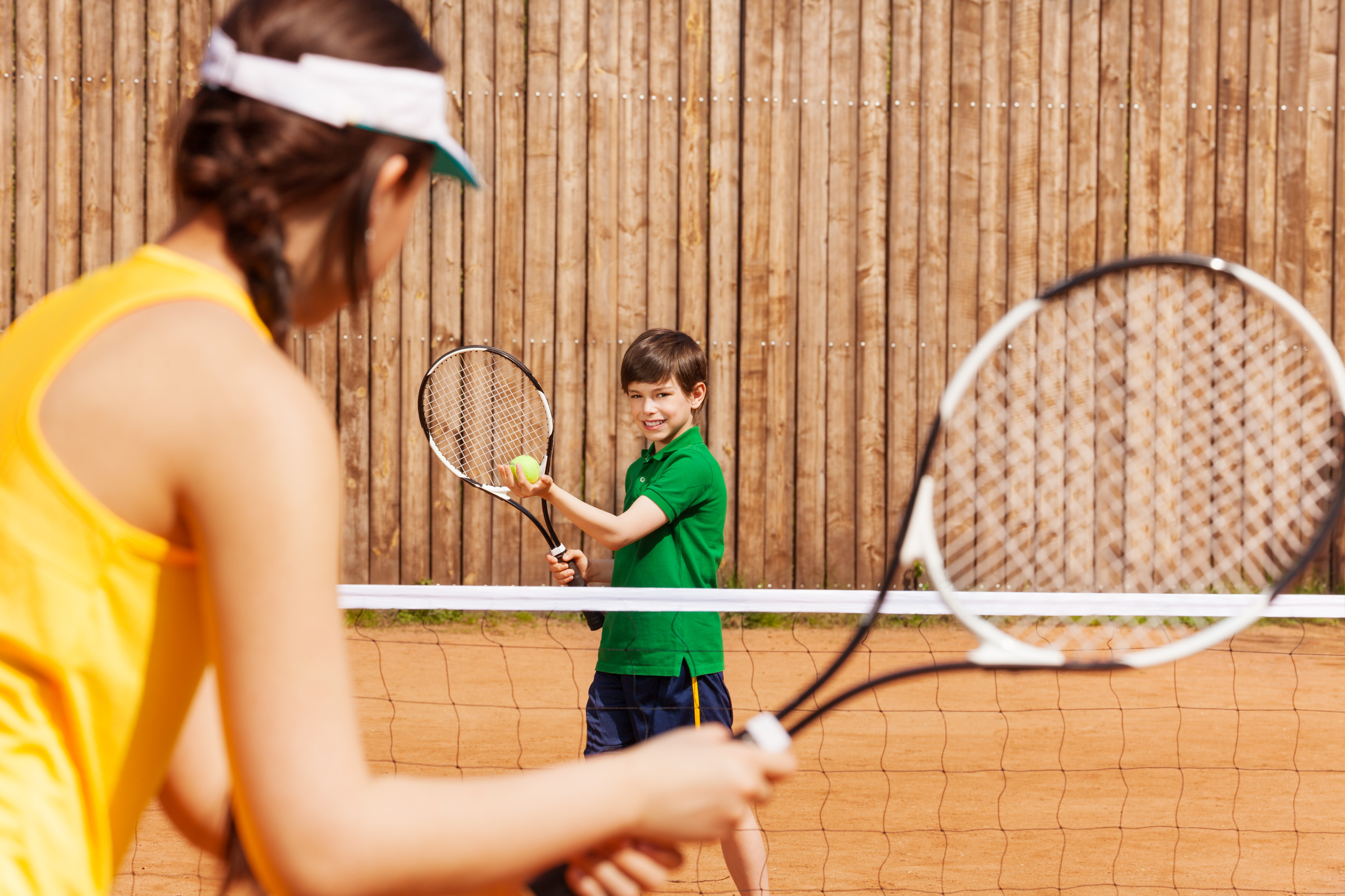 Bob enjoys tennis playing to play. Мальчик и девочка играют в теннис. Девочка с ракеткой. Игры с мячом и ракеткой. Веселая фотосессия с ракеткой.